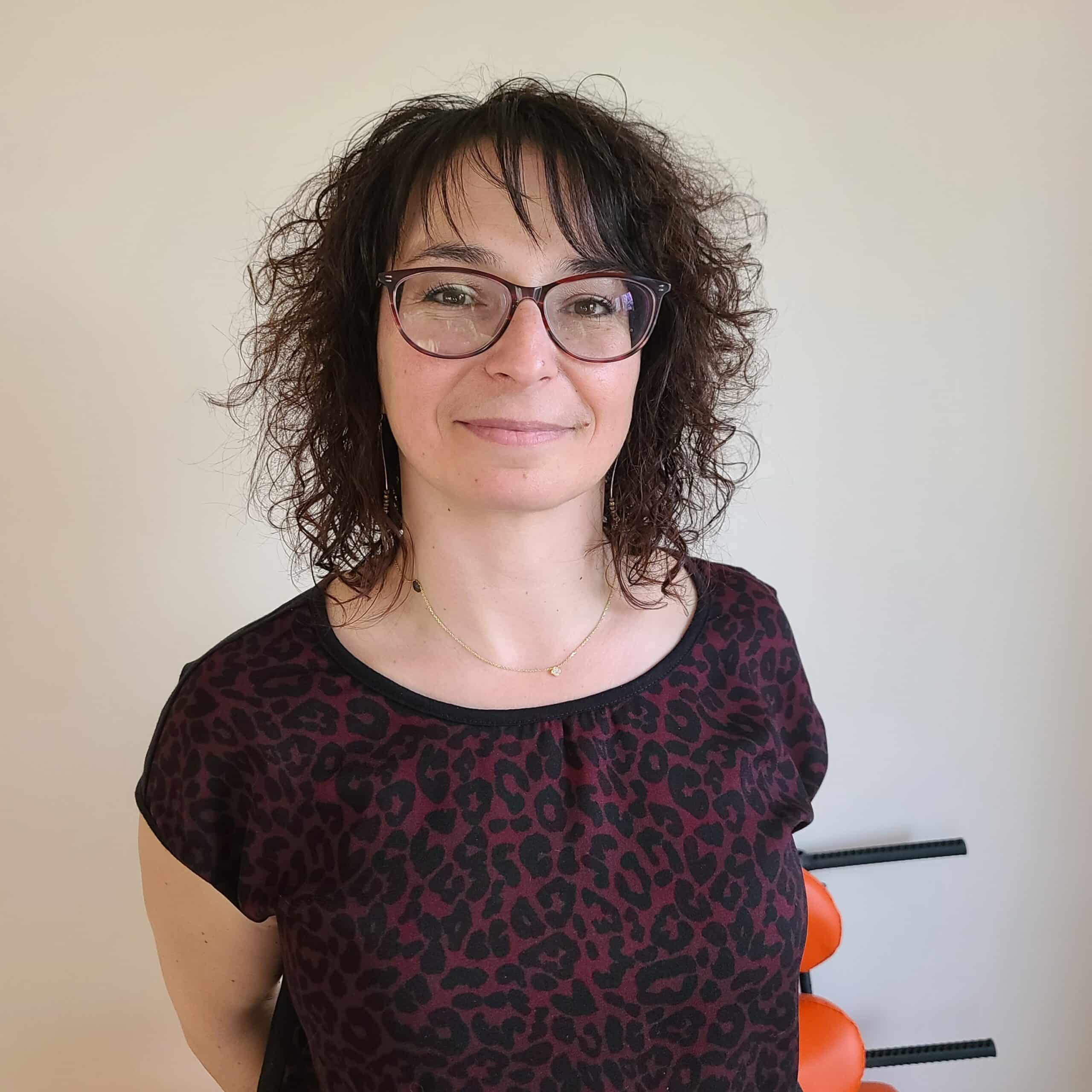 image d'une femme brune frisée avec des lunettes